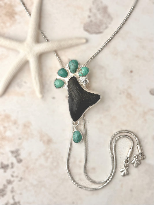 Sterling silver statement, Bolo Necklace with a megalodon fossil tooth and green turquoise on a textured surface