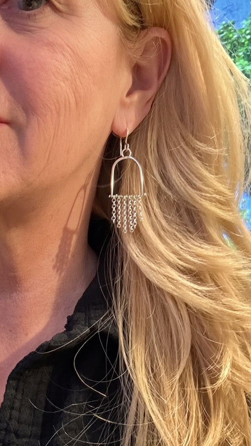 Sun Salt Silver Arizona Peridot arch earrings worn on ear, chain fringe movement, desert-inspired handcrafted jewelry