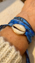 Cowrie shell silk wrap bracelet in fine and sterling silver with hand-dyed silk ribbon.