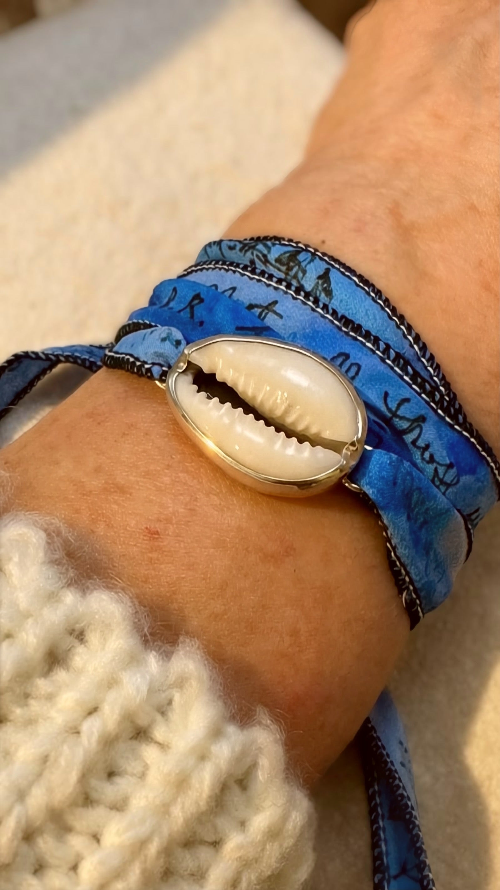 Cowrie shell silk wrap bracelet in fine and sterling silver with hand-dyed silk ribbon.