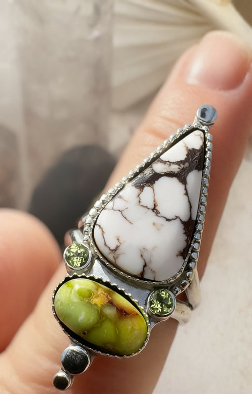 White Horse and Palomino stone statement ring with peridot accents set in fine and sterling silver on a finger.