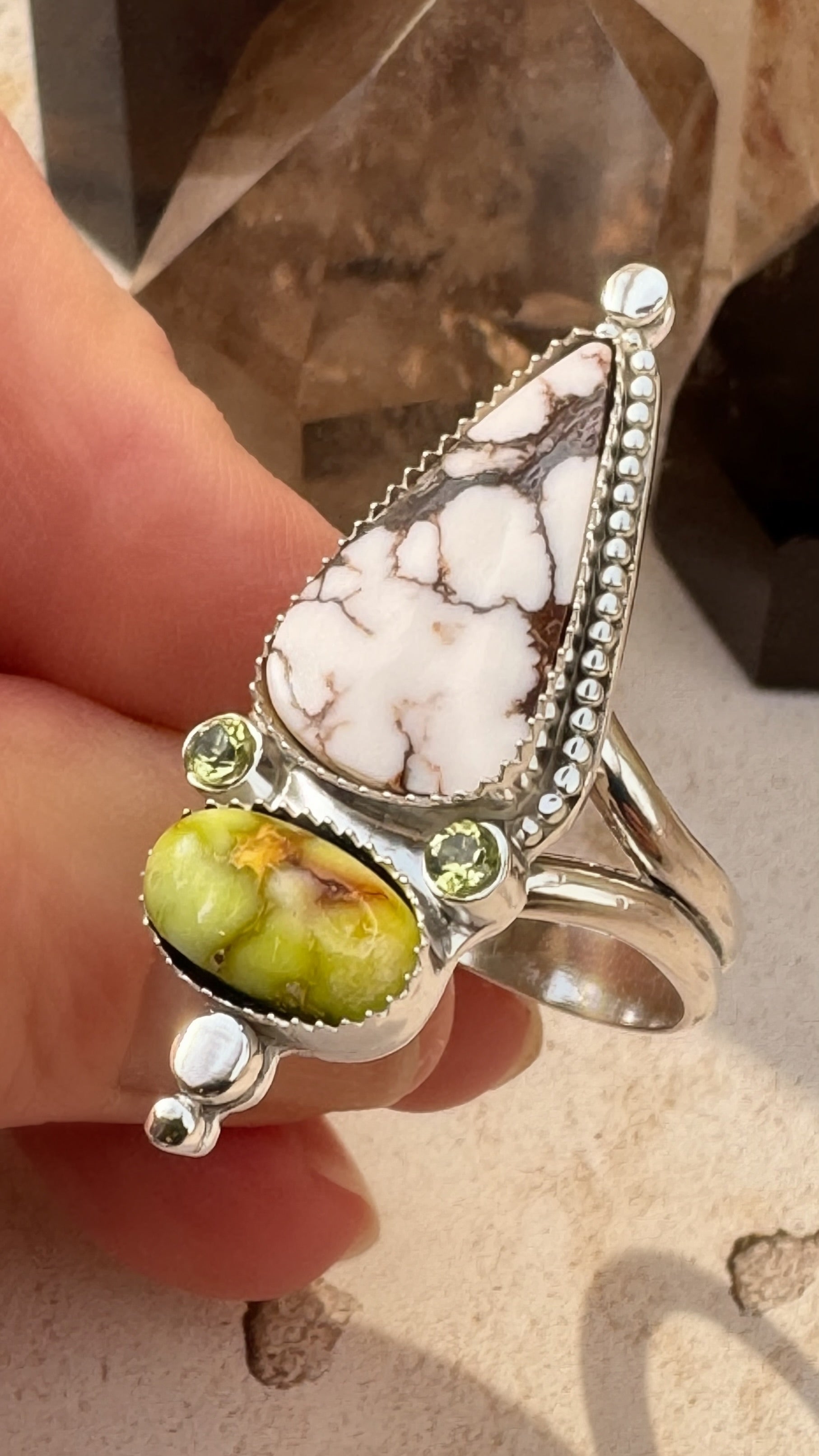 White Horse and Palomino stone statement ring with peridot accents set in fine and sterling silver against a neutral background.