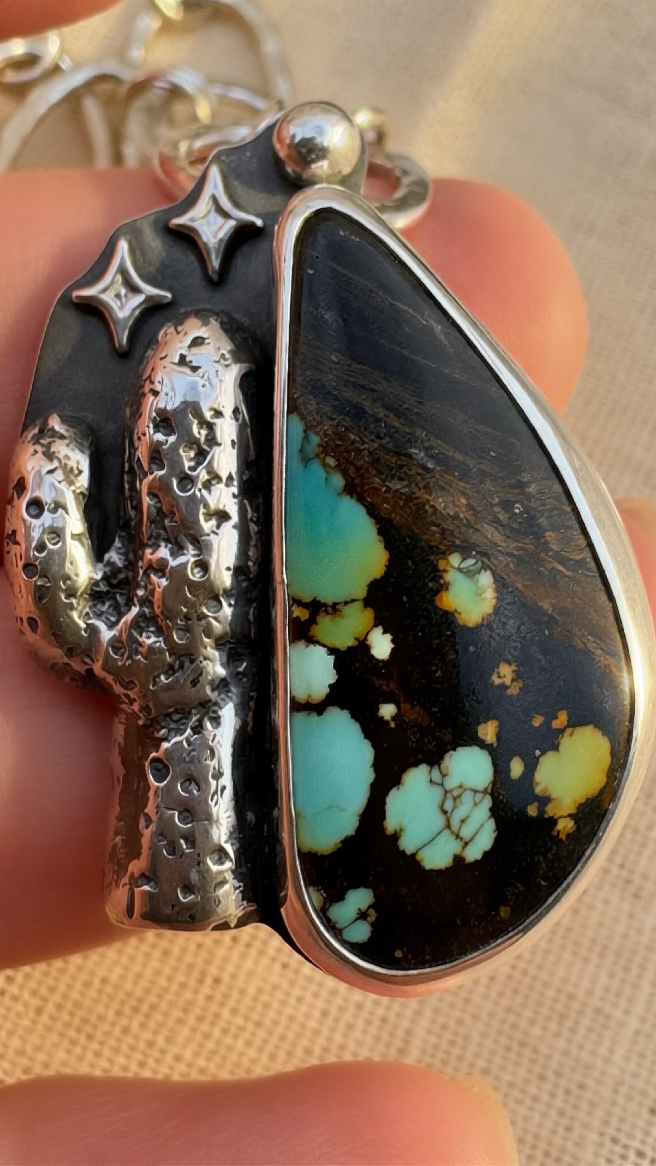 Close-up of black matrix Hubei turquoise cabochon set in oxidized silver