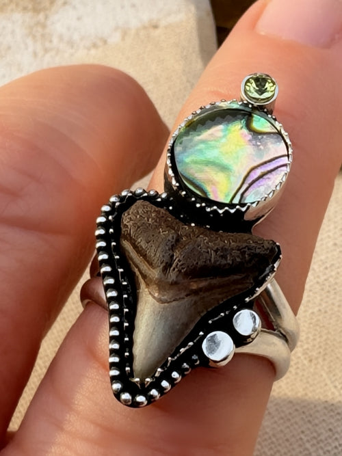 Shark tooth, abalone and peridot ring being worn.