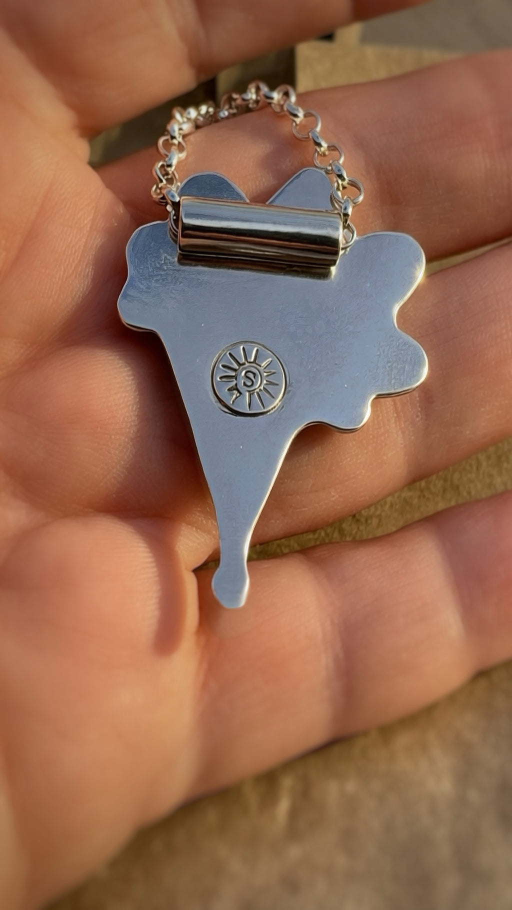 Backside of the sterling silver pendant including the bail detail and makers mark.