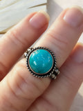 Round blue Bisbee turquoise ring in oxidized sterling silver with a twisted wire halo, handmade by Sun Salt Silver.