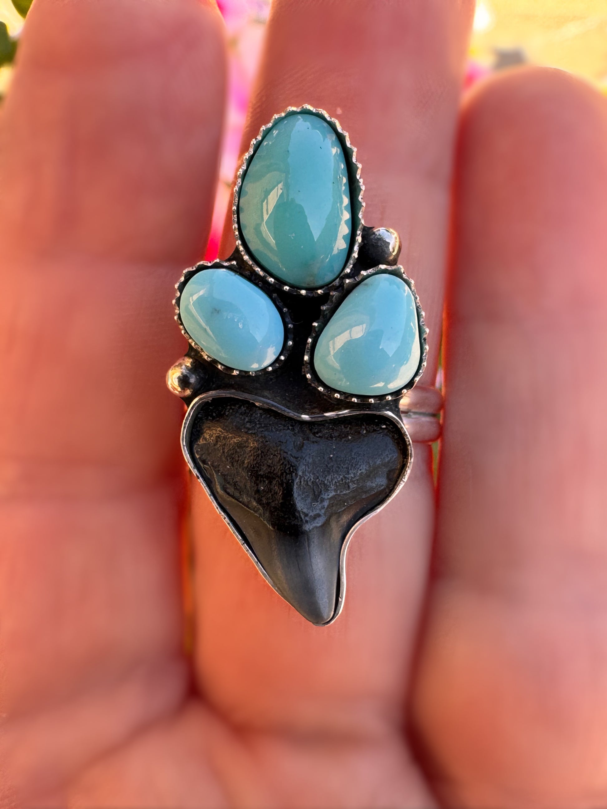 Ring with turquoise stones and shark tooth on a hand