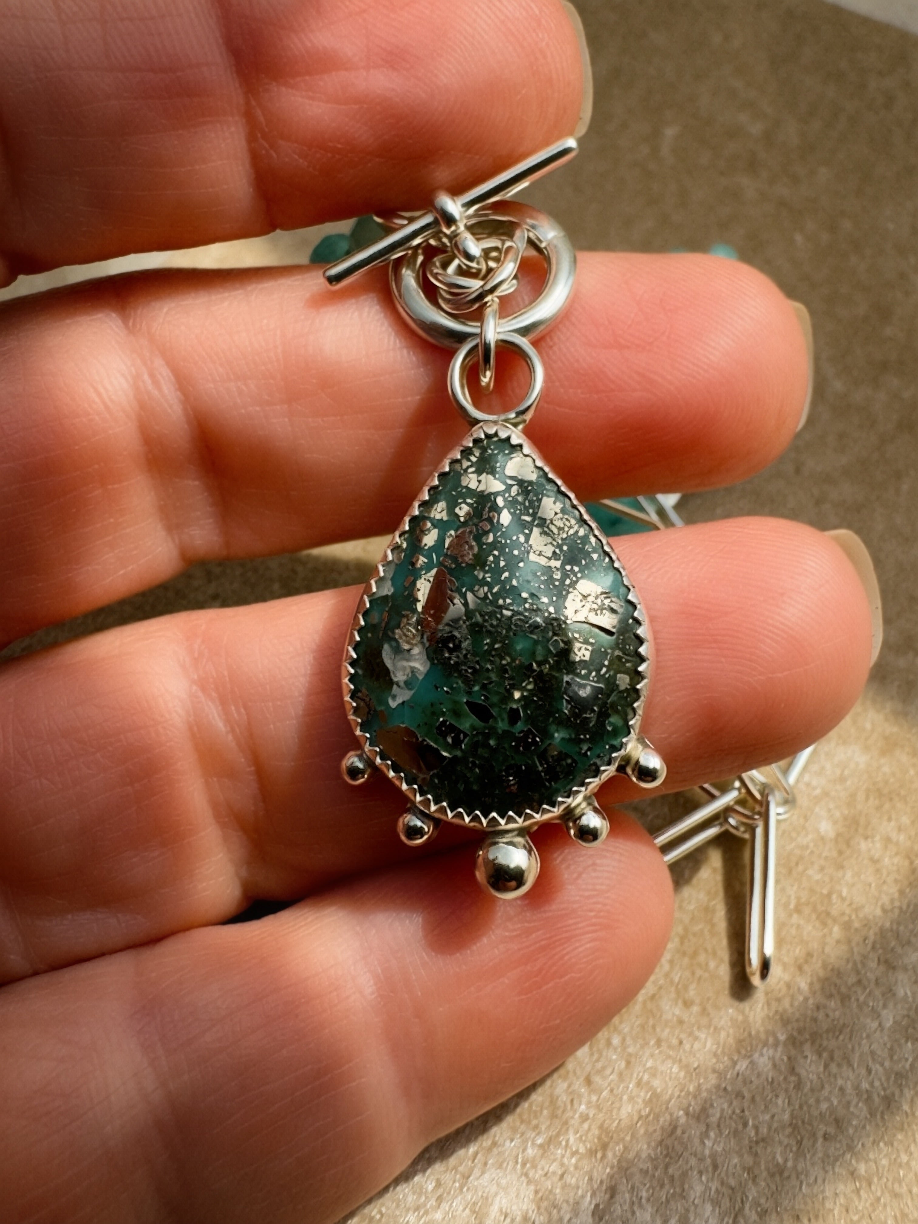 Natural pyrite-flecked turquoise teardrop cabochon in hand-fabricated sterling silver serrated bezel with granulation ball detail, Caye collection Sun Salt Silver