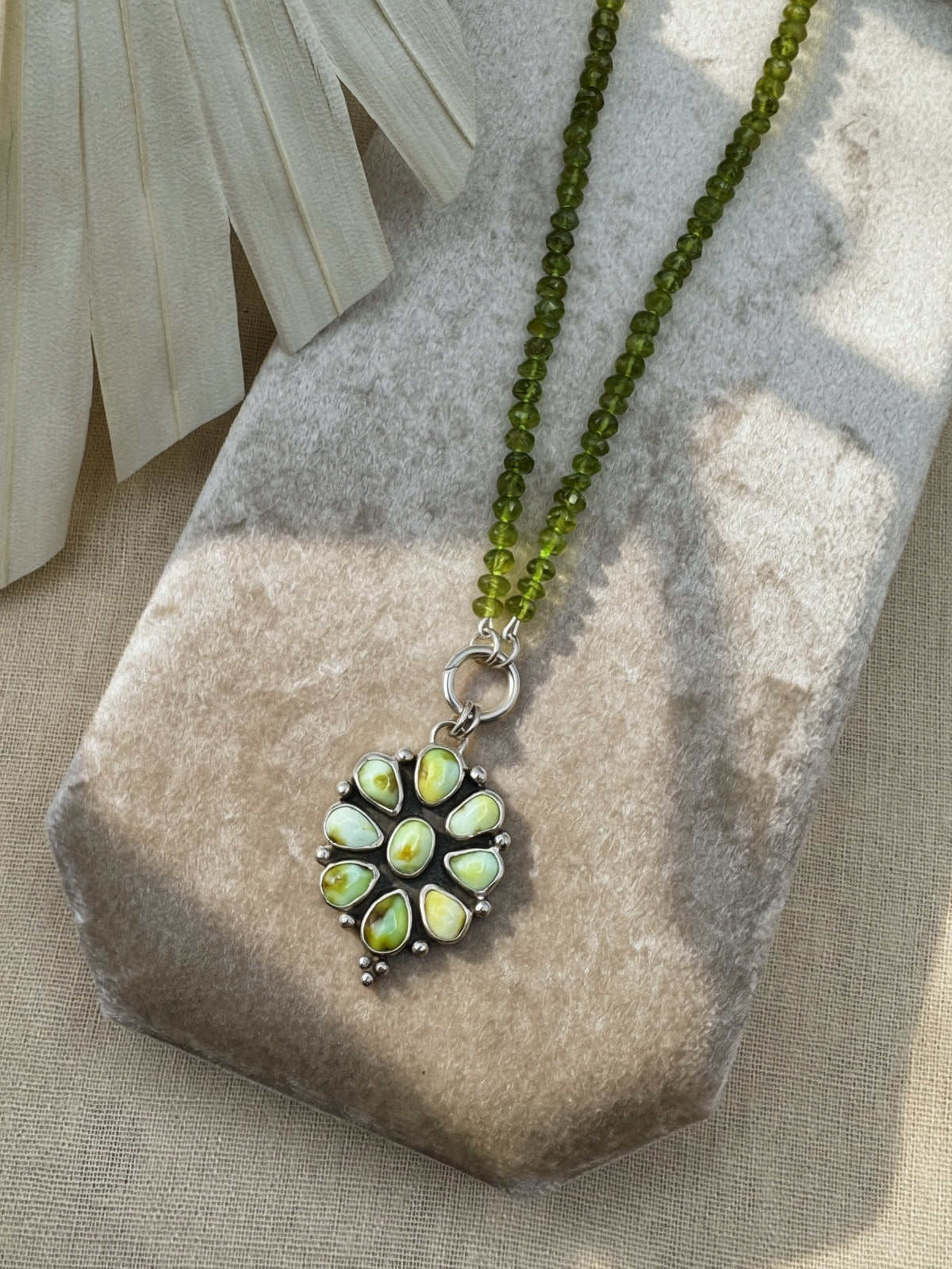 Verdant Sun statement necklace with nine green Palomino variscite stones, hand-knotted peridot beads and a sterling silver charm keeper.