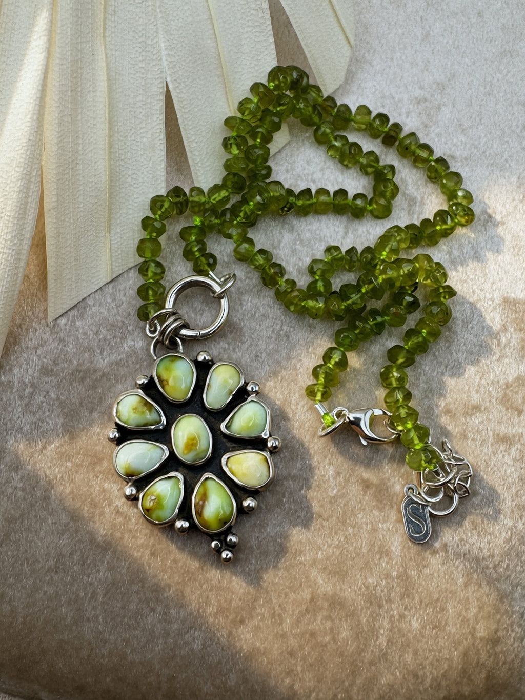 Verdant Sun statement necklace with nine green Palomino variscite stones, hand-knotted peridot beads and a sterling silver charm keeper.