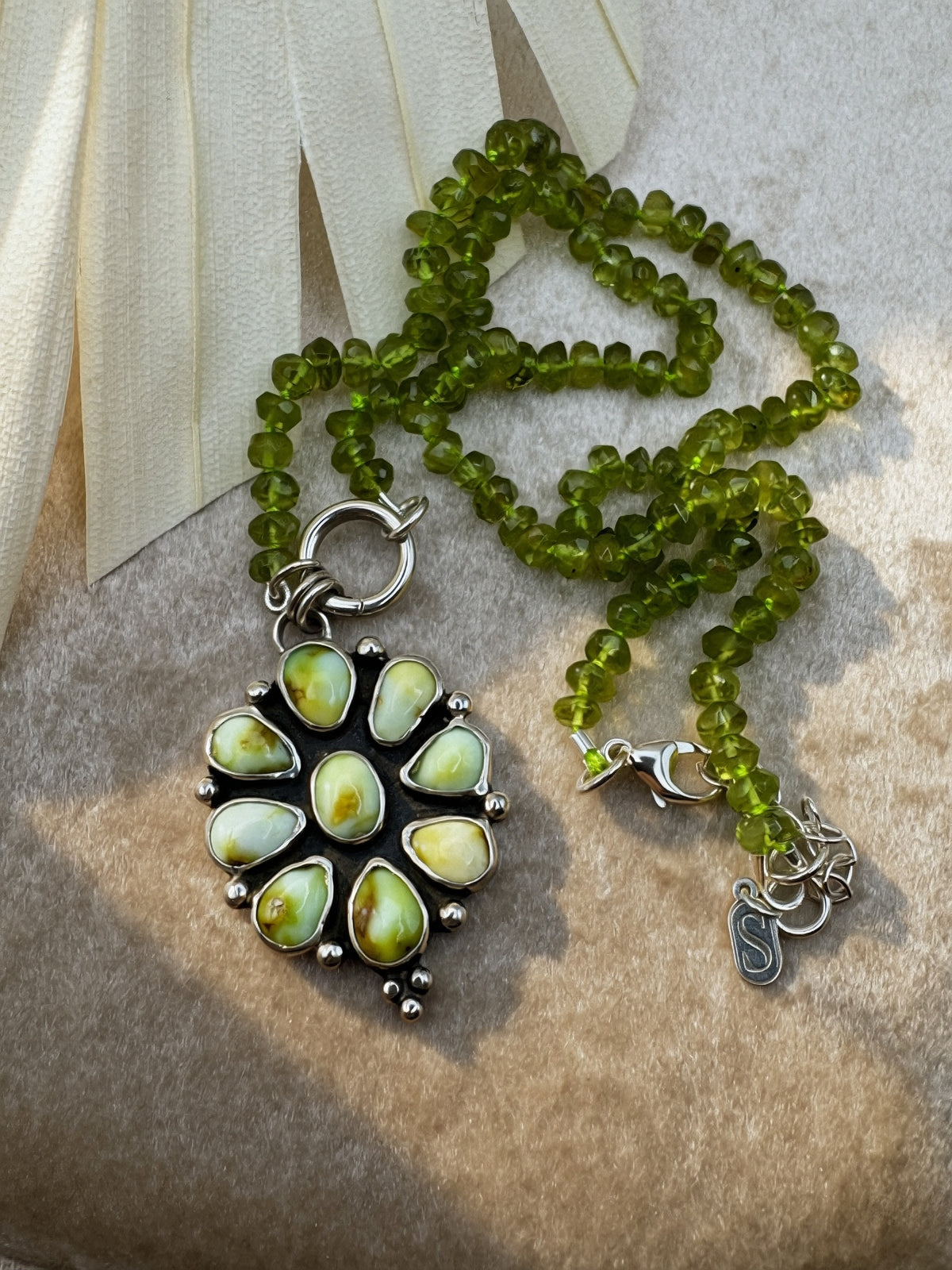 Verdant Sun statement necklace with nine green Palomino variscite stones, hand-knotted peridot beads and a sterling silver charm keeper.