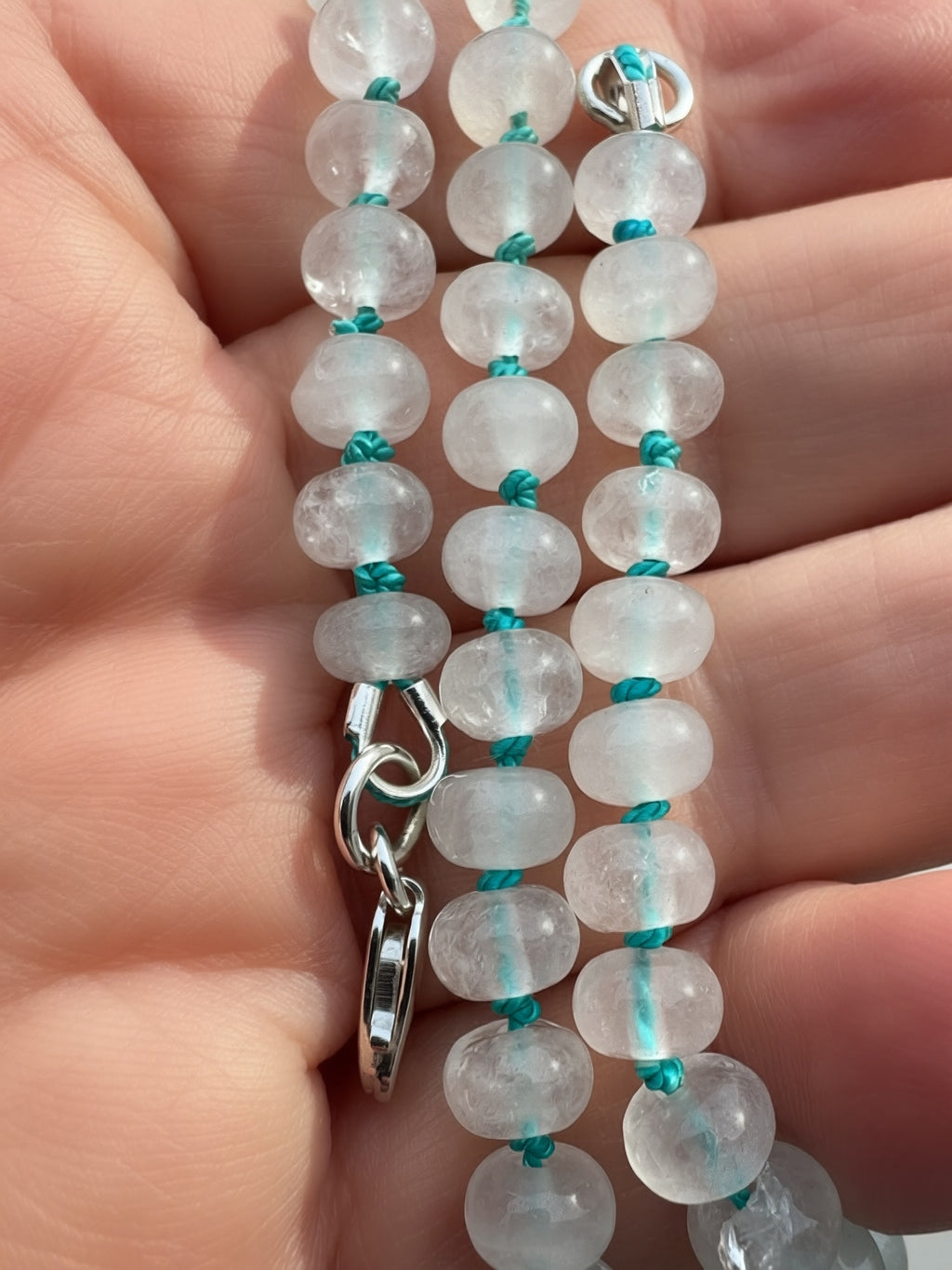 Close-up of candy jade rondelle beads hand knotted on turquoise silk thread