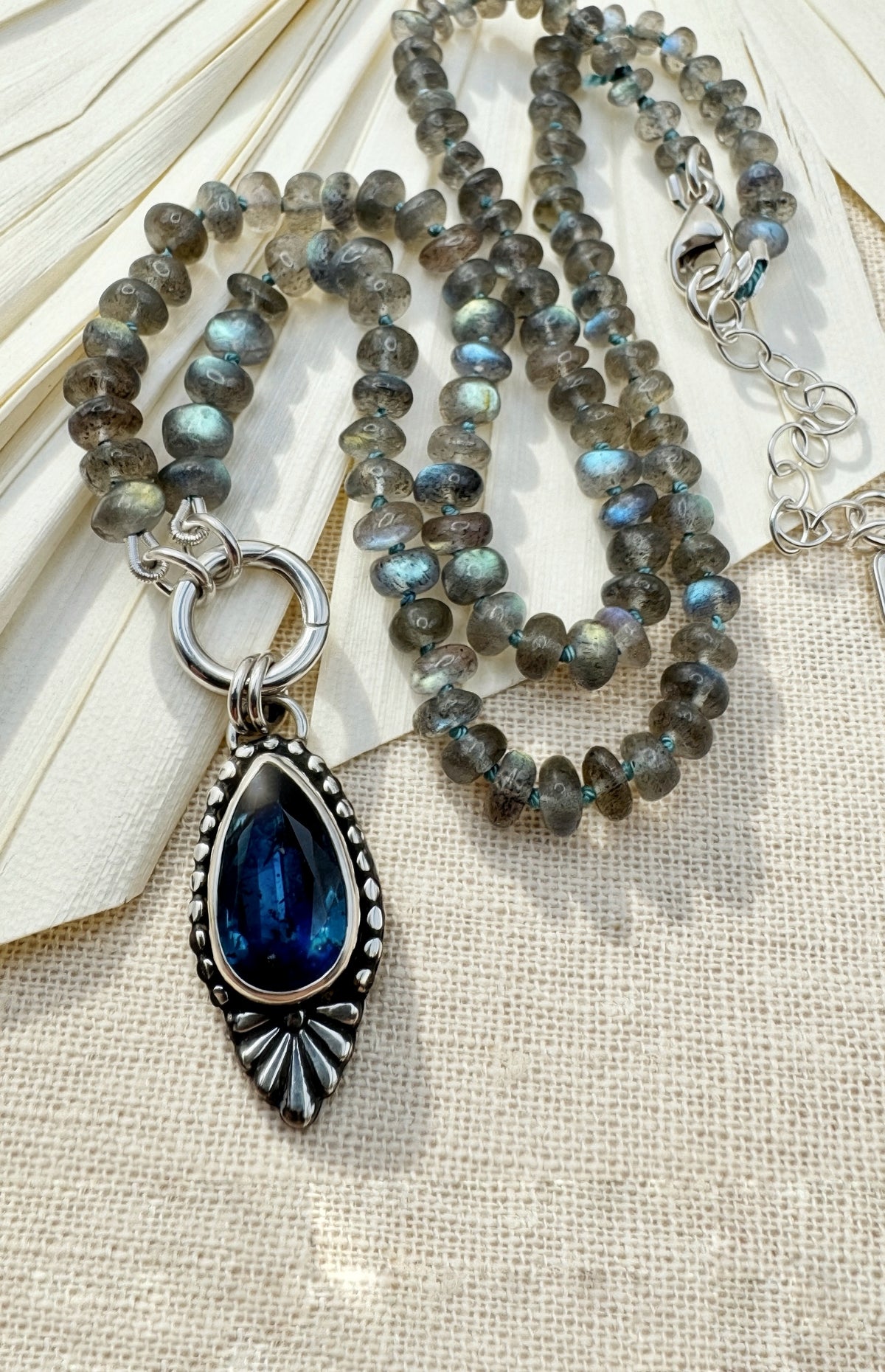 Full Blue Hour Bloom necklace with hand-knotted labradorite beads, sterling silver charm keeper and faceted teal kyanite floral pendant.