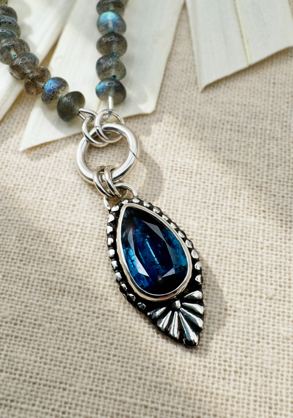 Full Blue Hour Bloom necklace with hand-knotted labradorite beads, sterling silver charm keeper and faceted teal kyanite floral pendant.