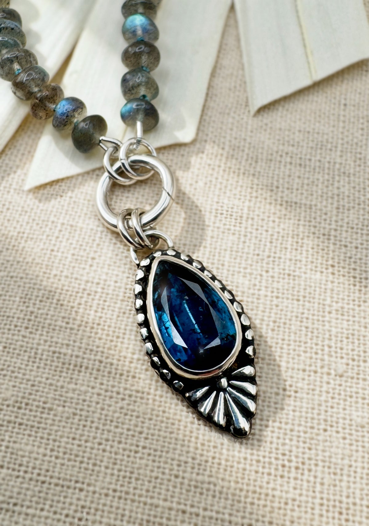 Full Blue Hour Bloom necklace with hand-knotted labradorite beads, sterling silver charm keeper and faceted teal kyanite floral pendant.