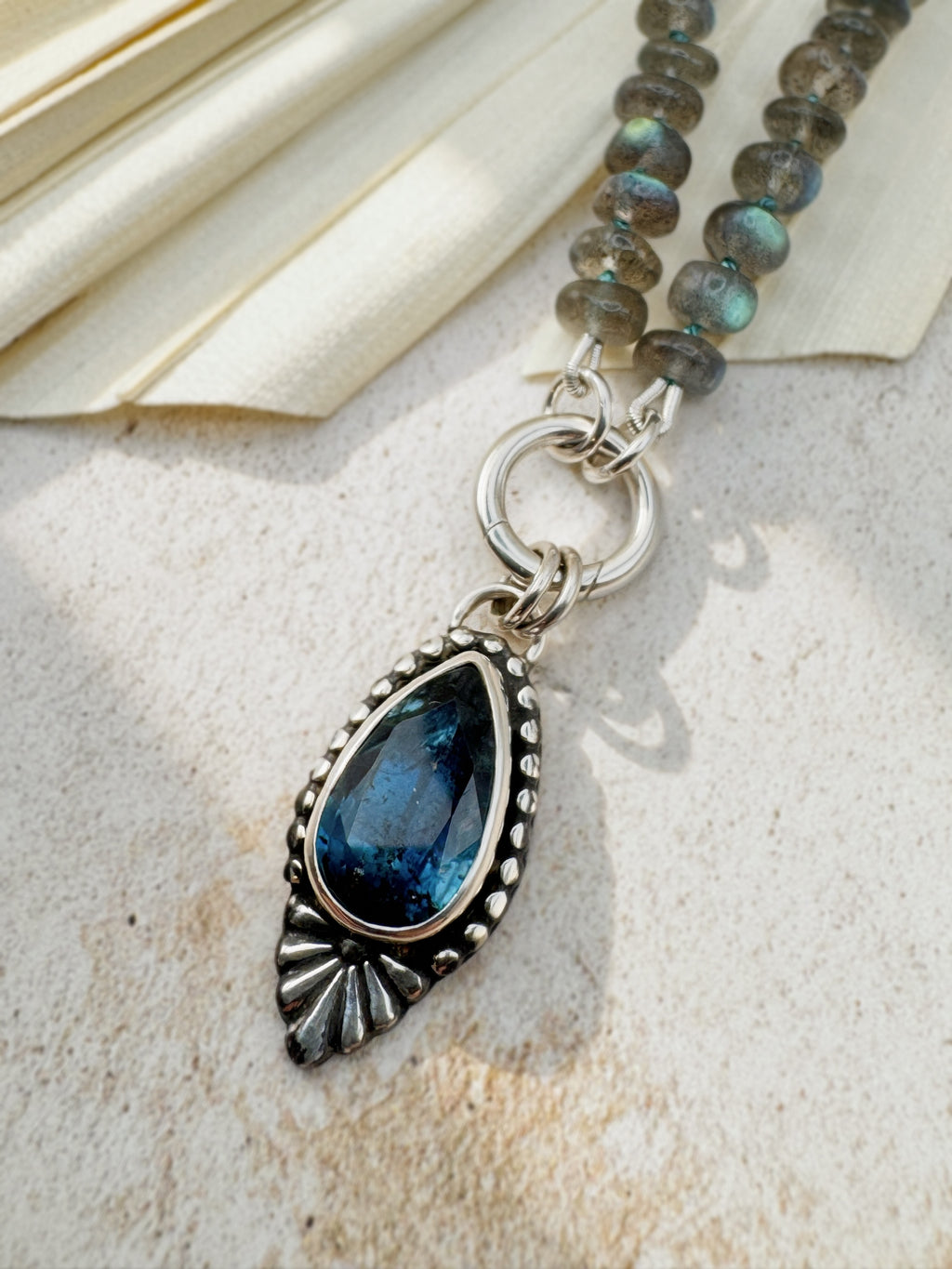 Full Blue Hour Bloom necklace with hand-knotted labradorite beads, sterling silver charm keeper and faceted teal kyanite floral pendant.