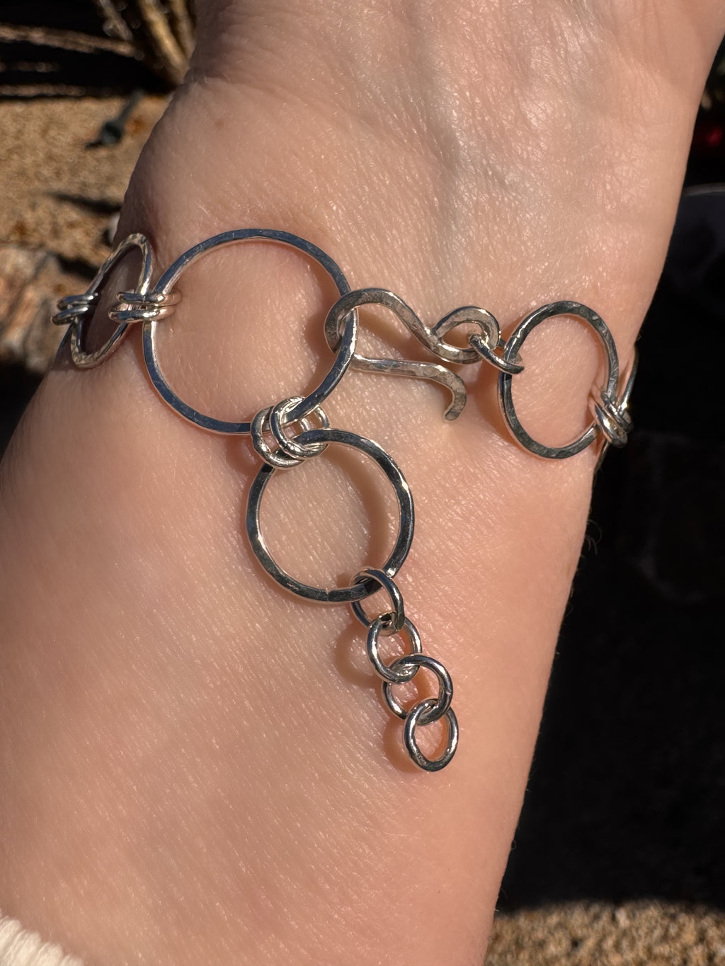 Hammered Silver bracelet on a wrist with a blurred background