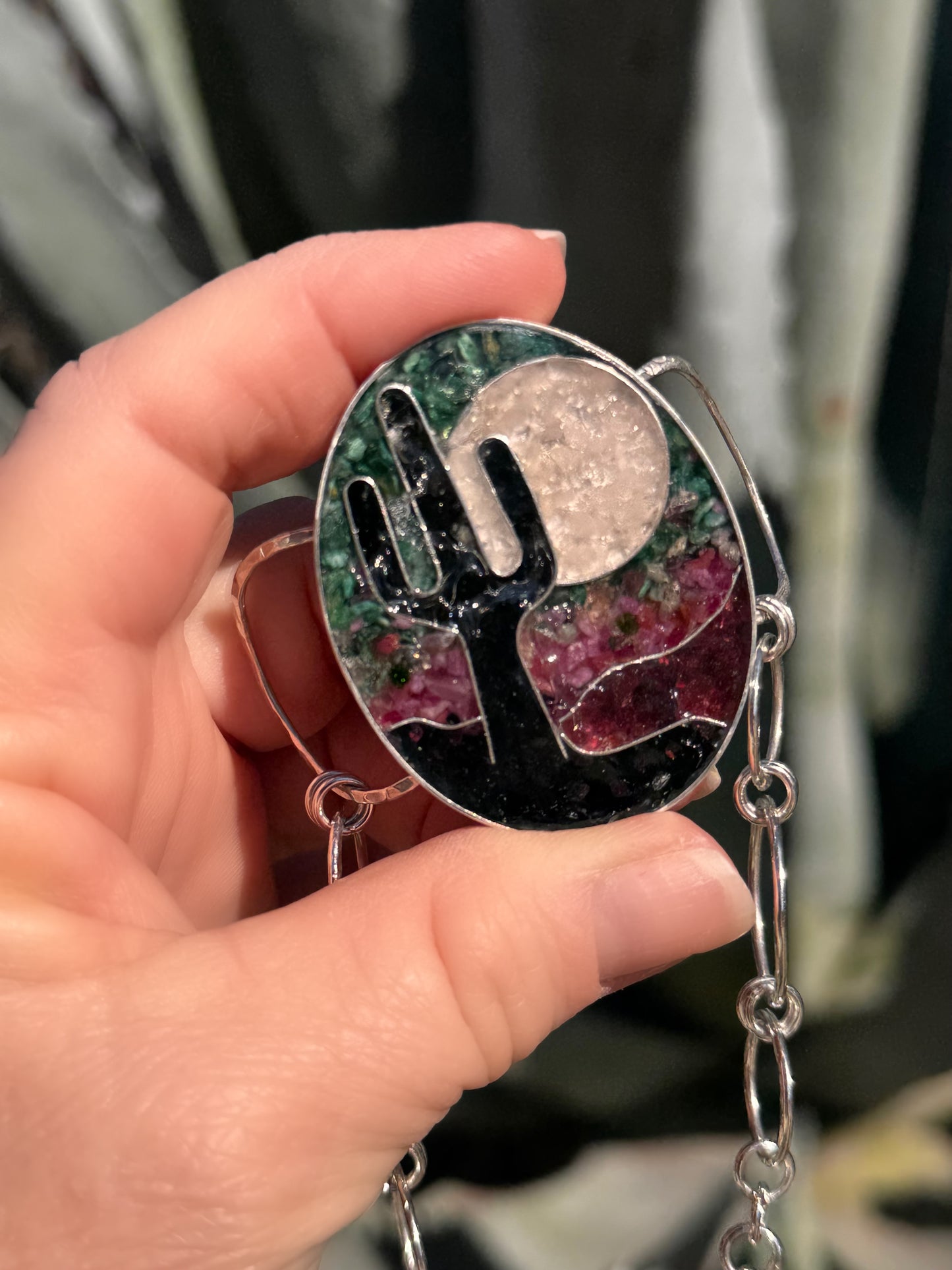 Hand holding a colorful bracelet with a design on a blurred background