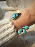 Turquoise multi stone bracelet on a wrist with a blurred background