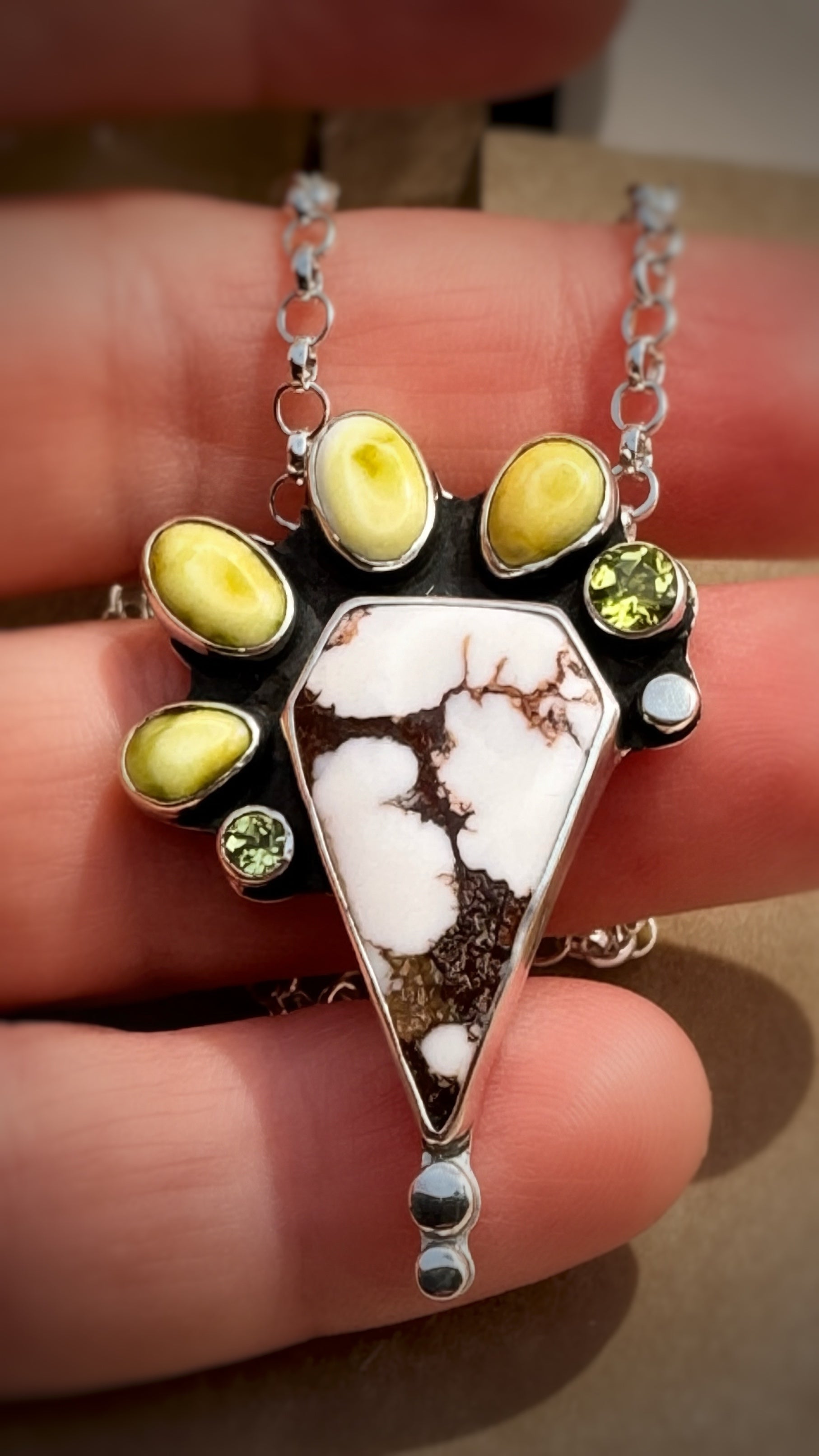 Close up of a Wild horse and variscite pendant in sterling silver with peridot accents, handcrafted one-of-a-kind necklace.