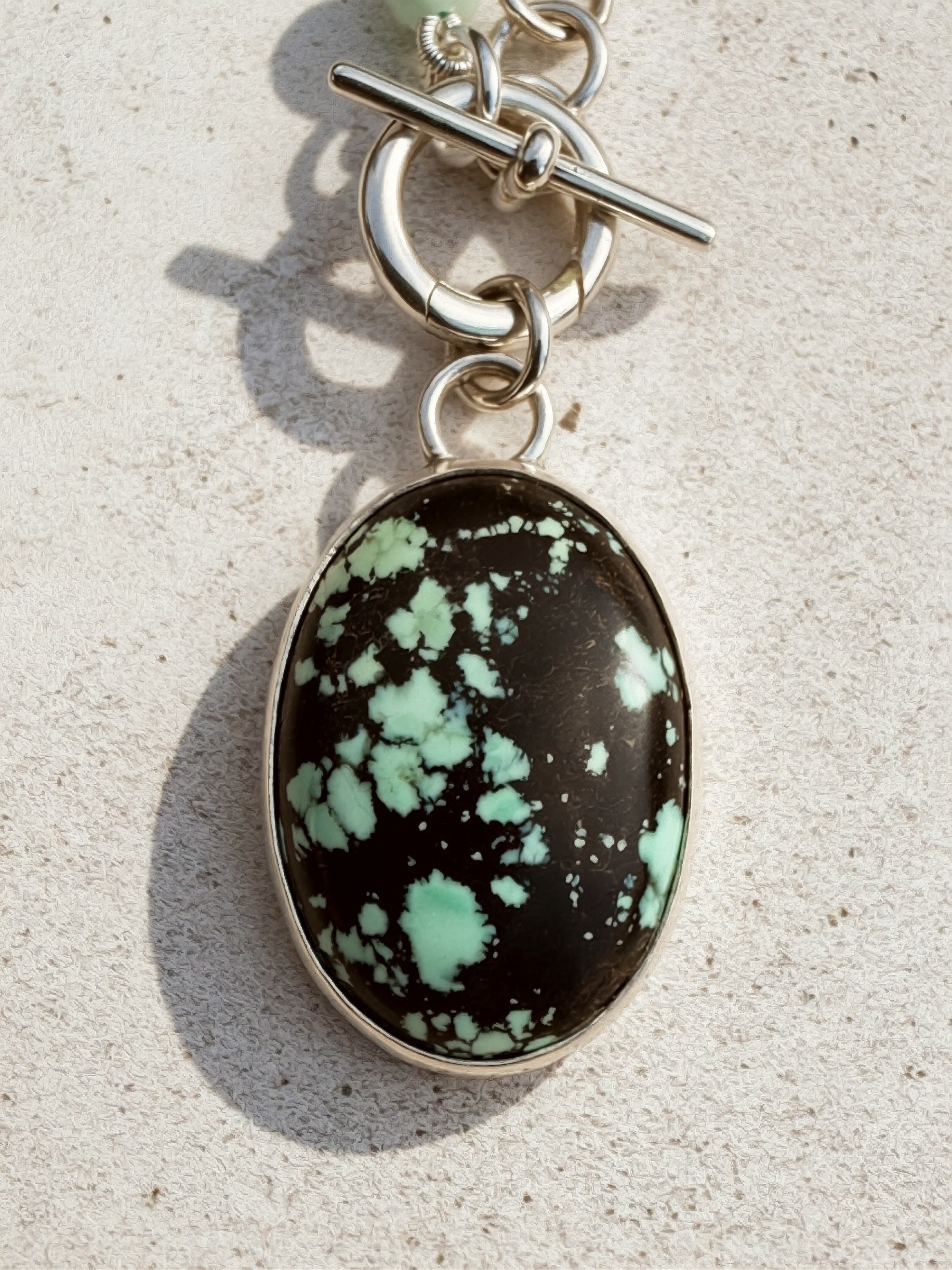 Carico Lake Variscite oval cabochon with black matrix and mint-green, set in high-polish sterling silver bezel, Sun Salt Silver