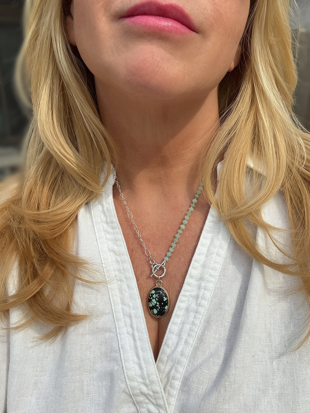 Handmade sterling silver Carico Lake Variscite charm keeper toggle necklace with hand-knotted seafoam rondelles and oval link chain being worn by a woman, Sun Salt Silver Caye collection