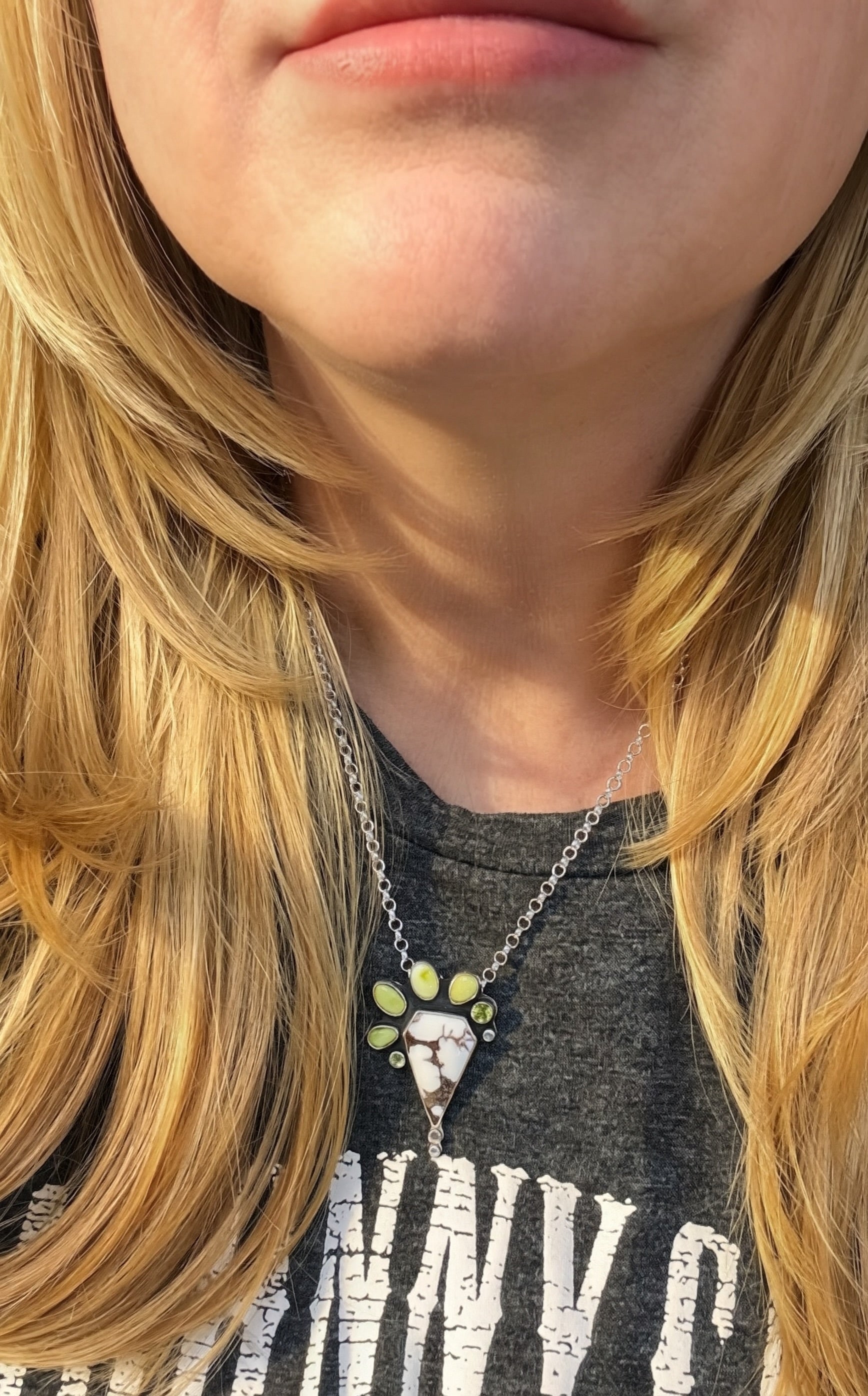 Close up of Woman wearing a wild horse and variscite stone pendant necklace on 18-inch sterling silver chain Wearing a gray band t-shirt