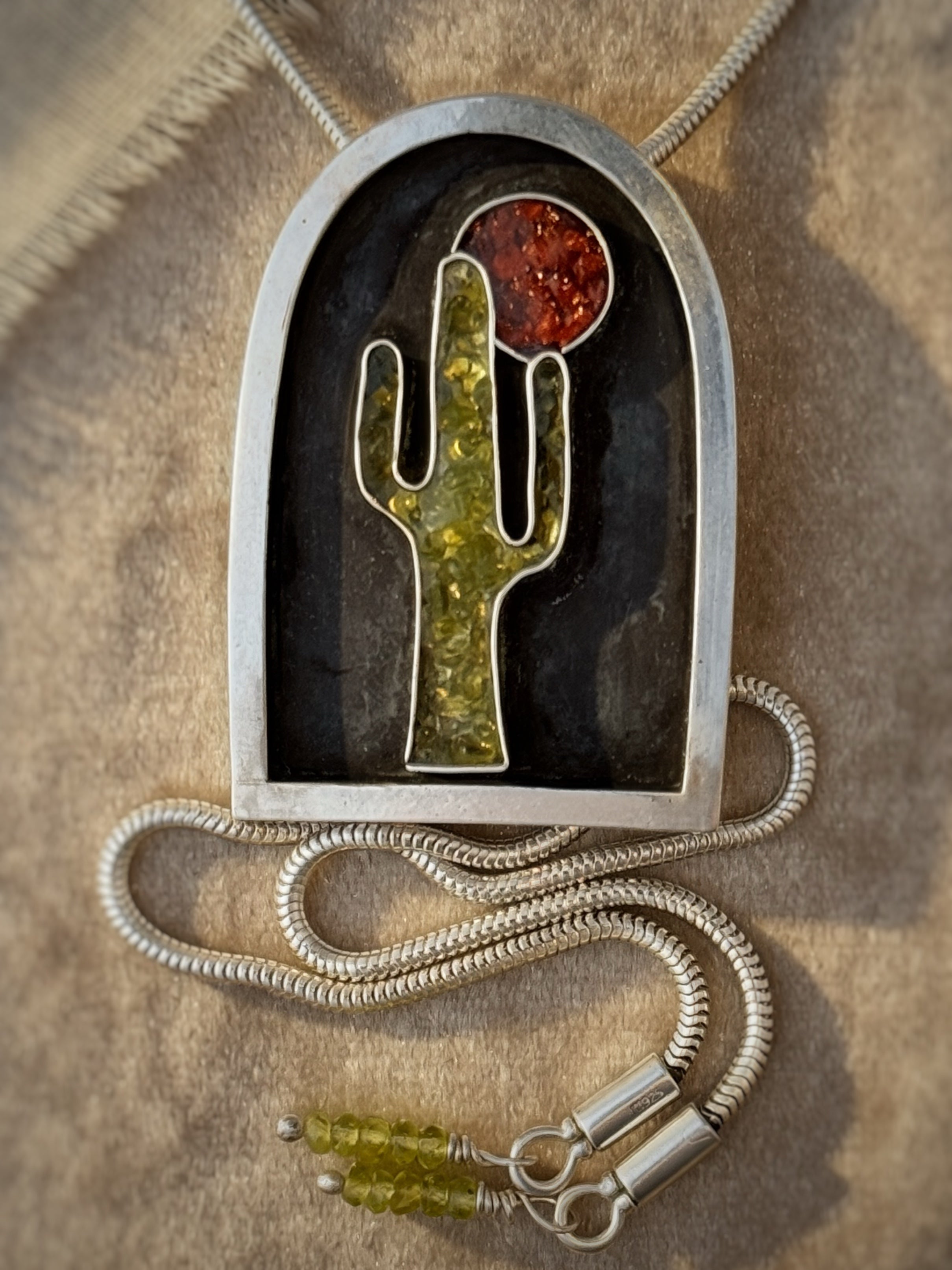 Pendant with cactus design on a textured surface