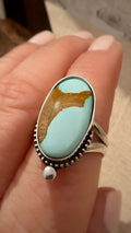 Turquoise ring with silver band on a finger