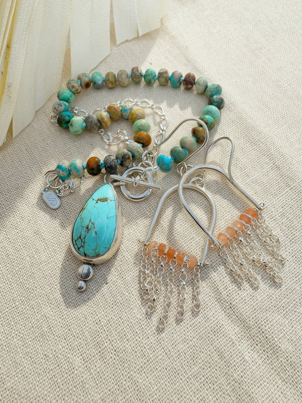 Glacier blue turquoise teardrop pendant in sterling silver bezel setting with natural turquoise rondelle bead strand and charm keeper toggle clasp, Sun Salt Silver Caye Collection And SILVER  fringe and peach moonstone beaded earrings