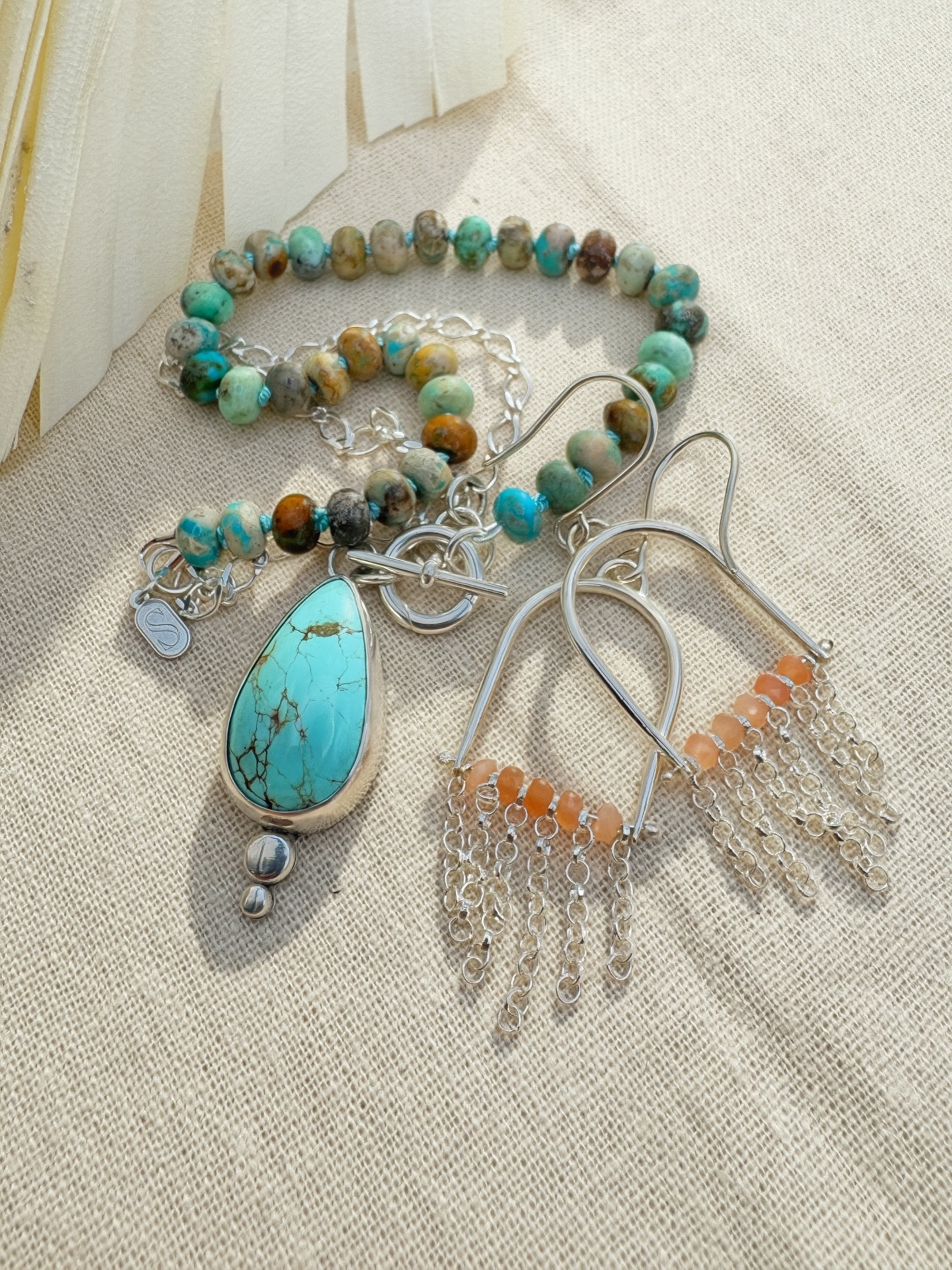 Glacier blue turquoise teardrop pendant in sterling silver bezel setting with natural turquoise rondelle bead strand and charm keeper toggle clasp, Sun Salt Silver Caye Collection And SILVER  fringe and peach moonstone beaded earrings