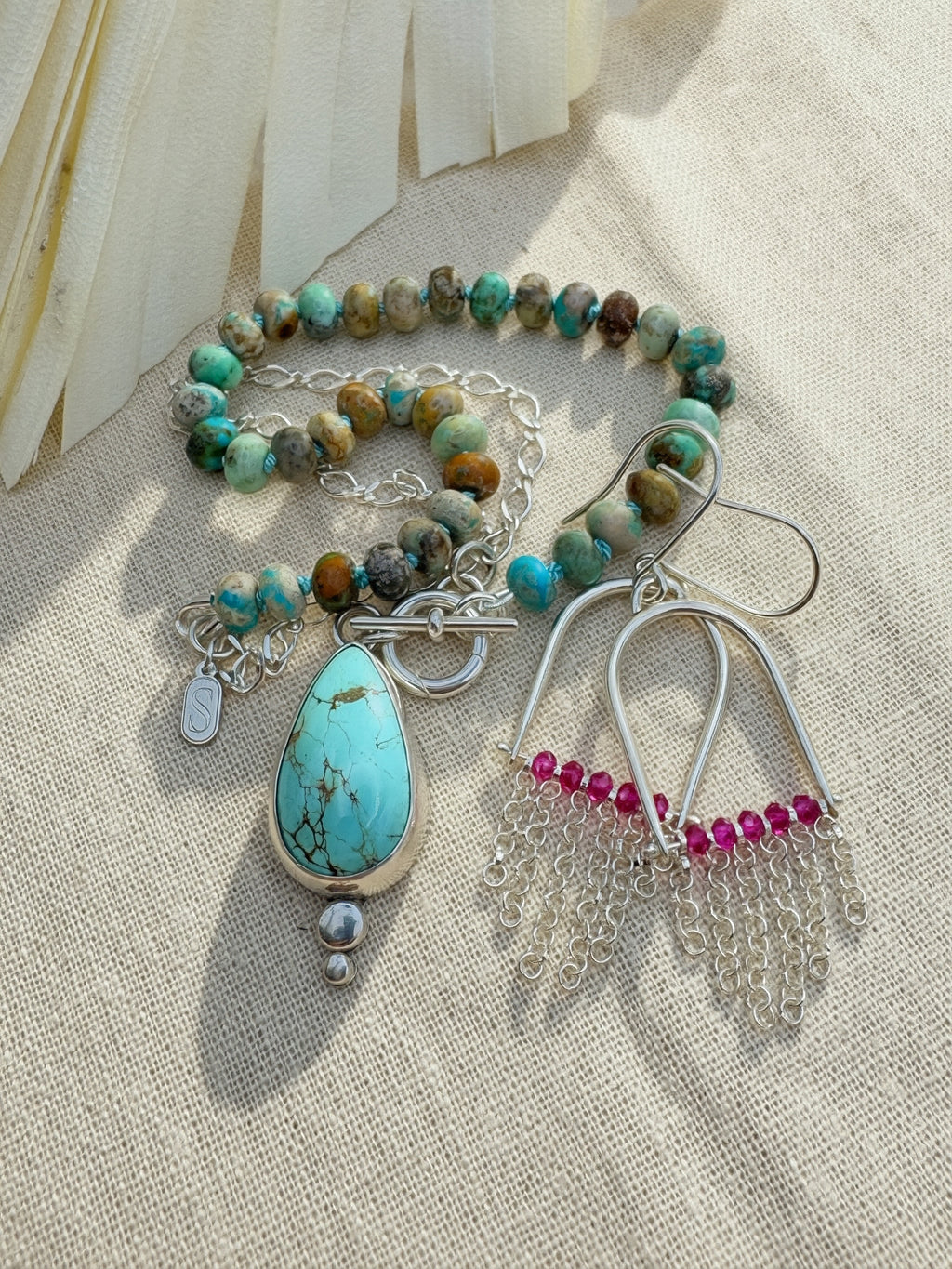 Glacier blue turquoise teardrop pendant in sterling silver bezel setting with natural turquoise rondelle bead strand and charm keeper toggle clasp, Sun Salt Silver Caye Collection And SILVER  fringe and ruby beaded earrings