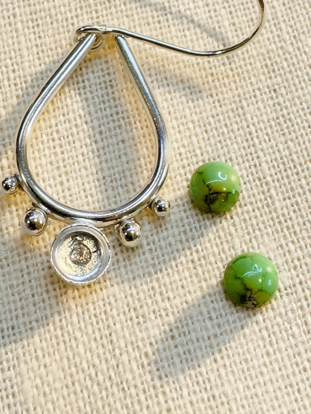 Close-up of natural Sonoran Gold Turquoise bezel set in sterling silver drop earring, golden matrix detail visible