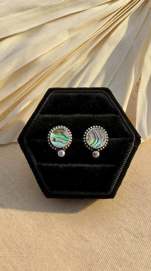 Natural abalone stud earrings showing blue and green iridescence