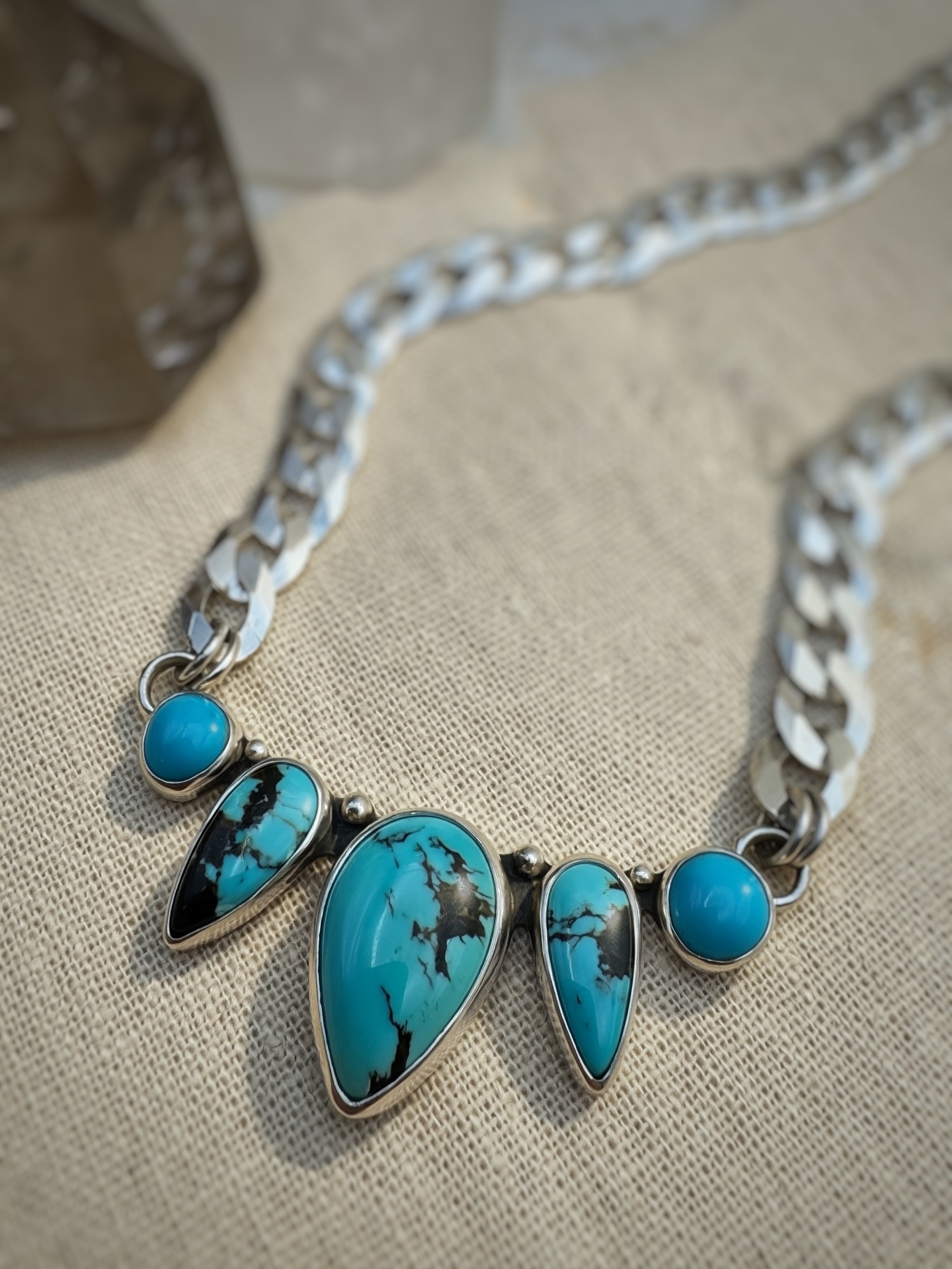 Five-stone turquoise necklace in sterling silver, showing Blue Dream matrix and Sleeping Beauty cabochons on 7.5mm curb chain