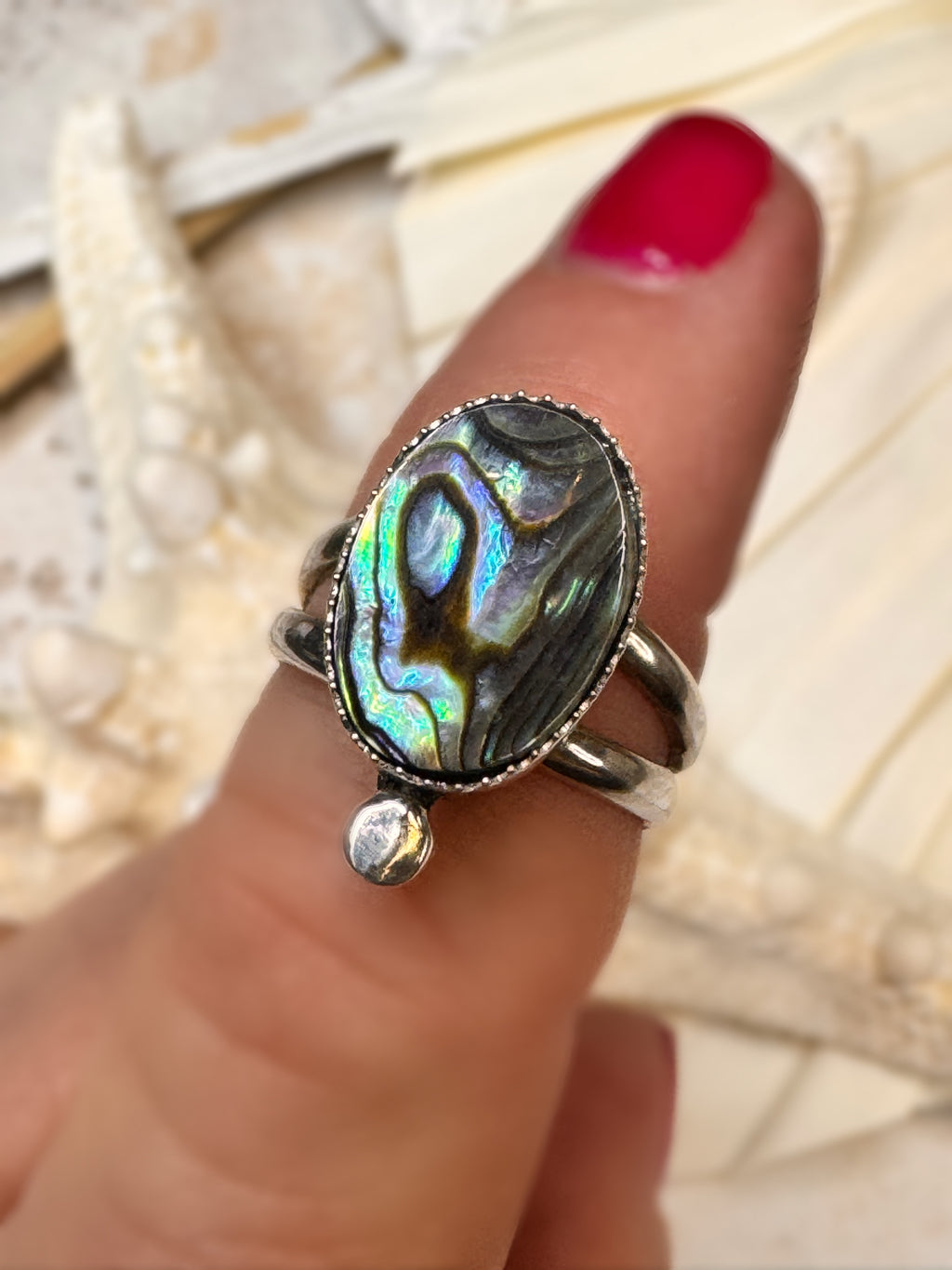 Abalone shell ring on a finger