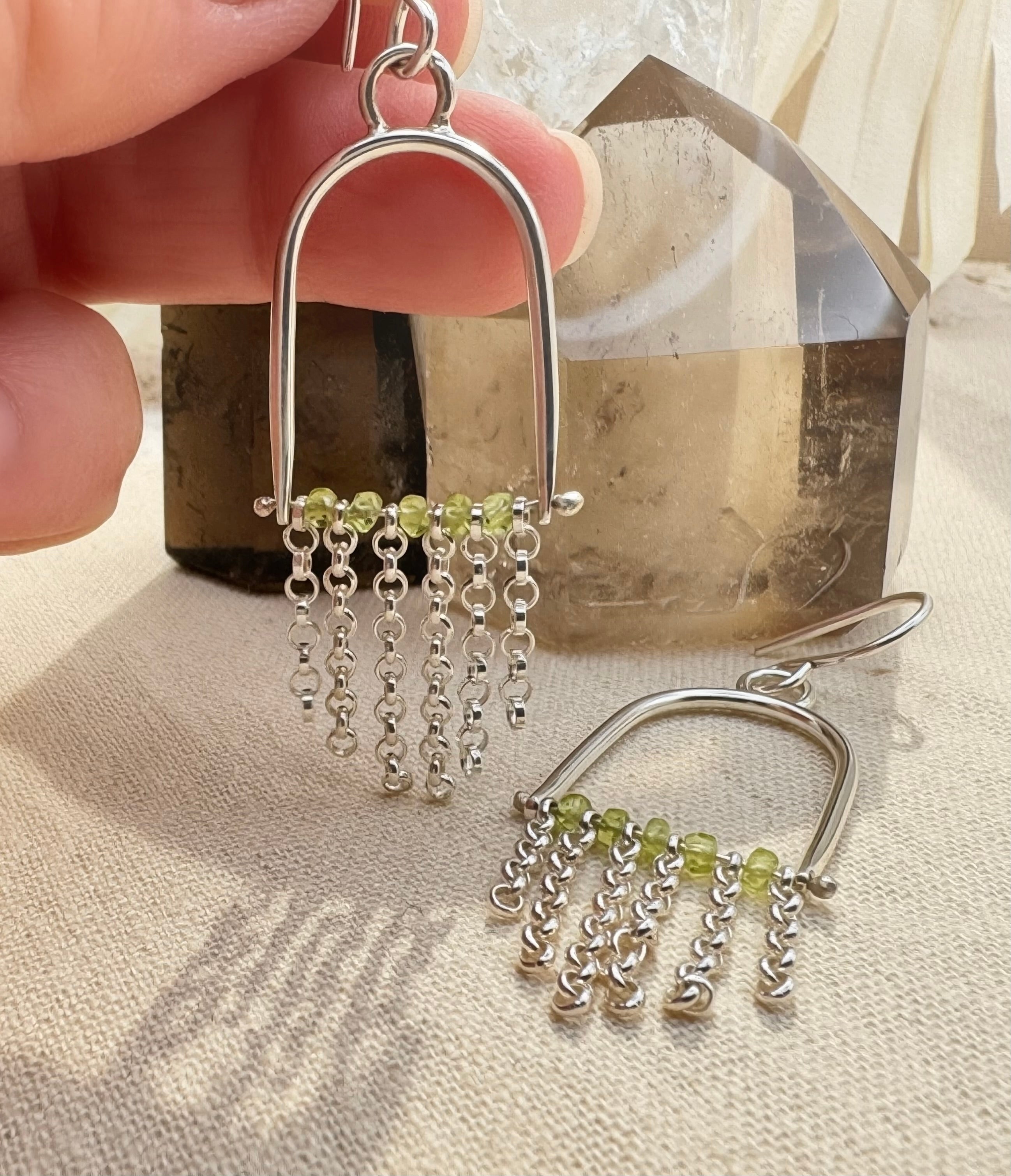 Close-up of natural Arizona Peridot beads with sterling silver chain fringe earring, volcanic gemstone detail