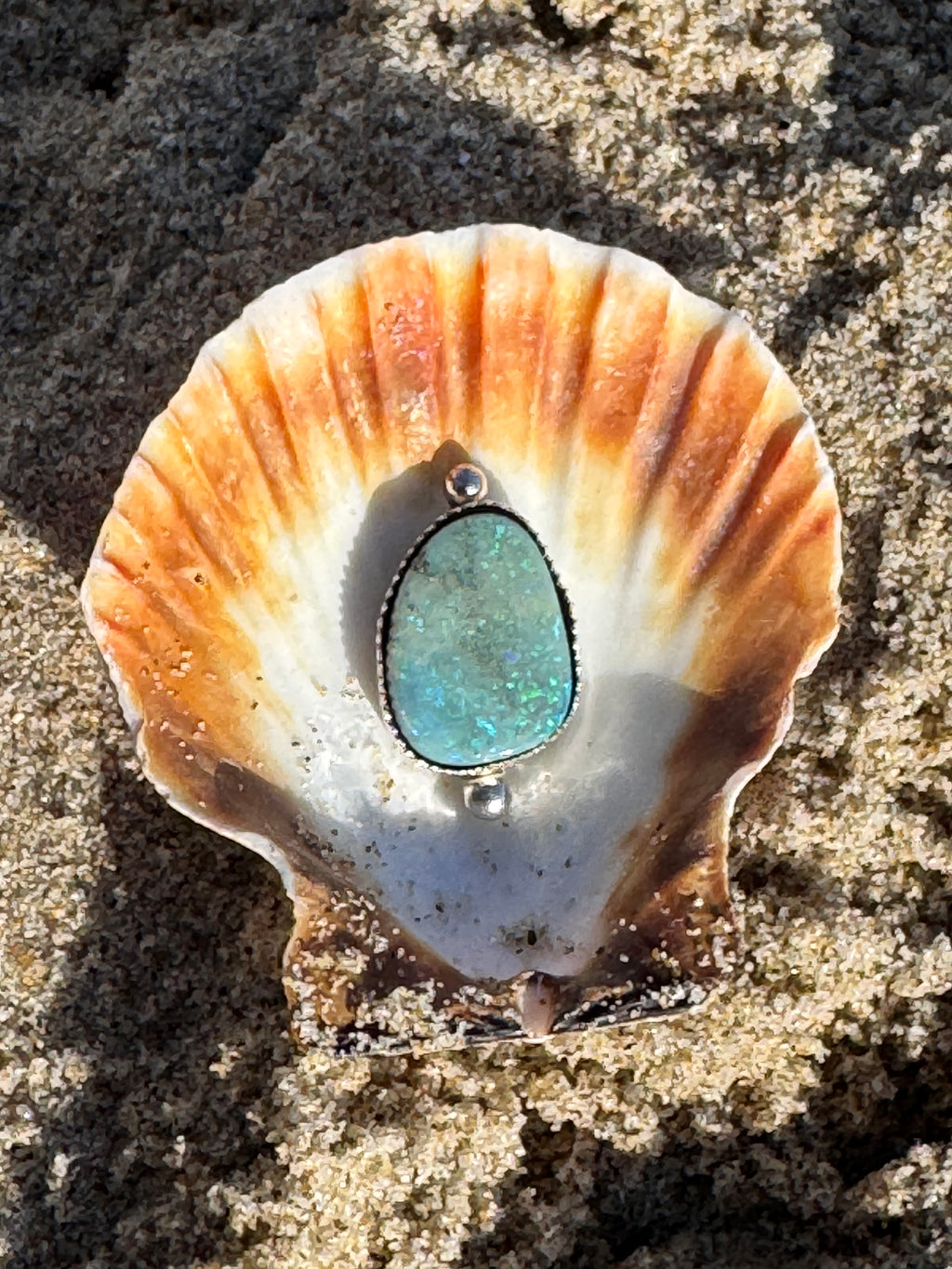 Ring with an opal showcased in a sea shell.