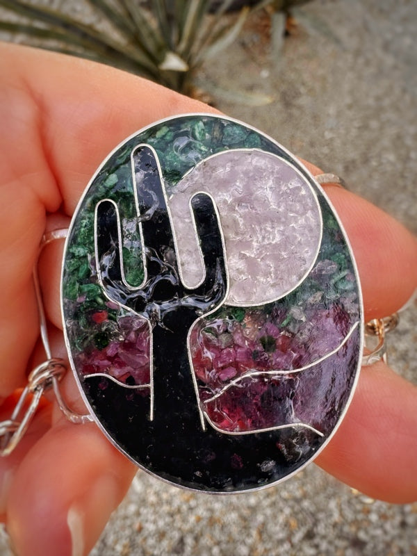 Handmade bracelet with a cactus design held by a hand.