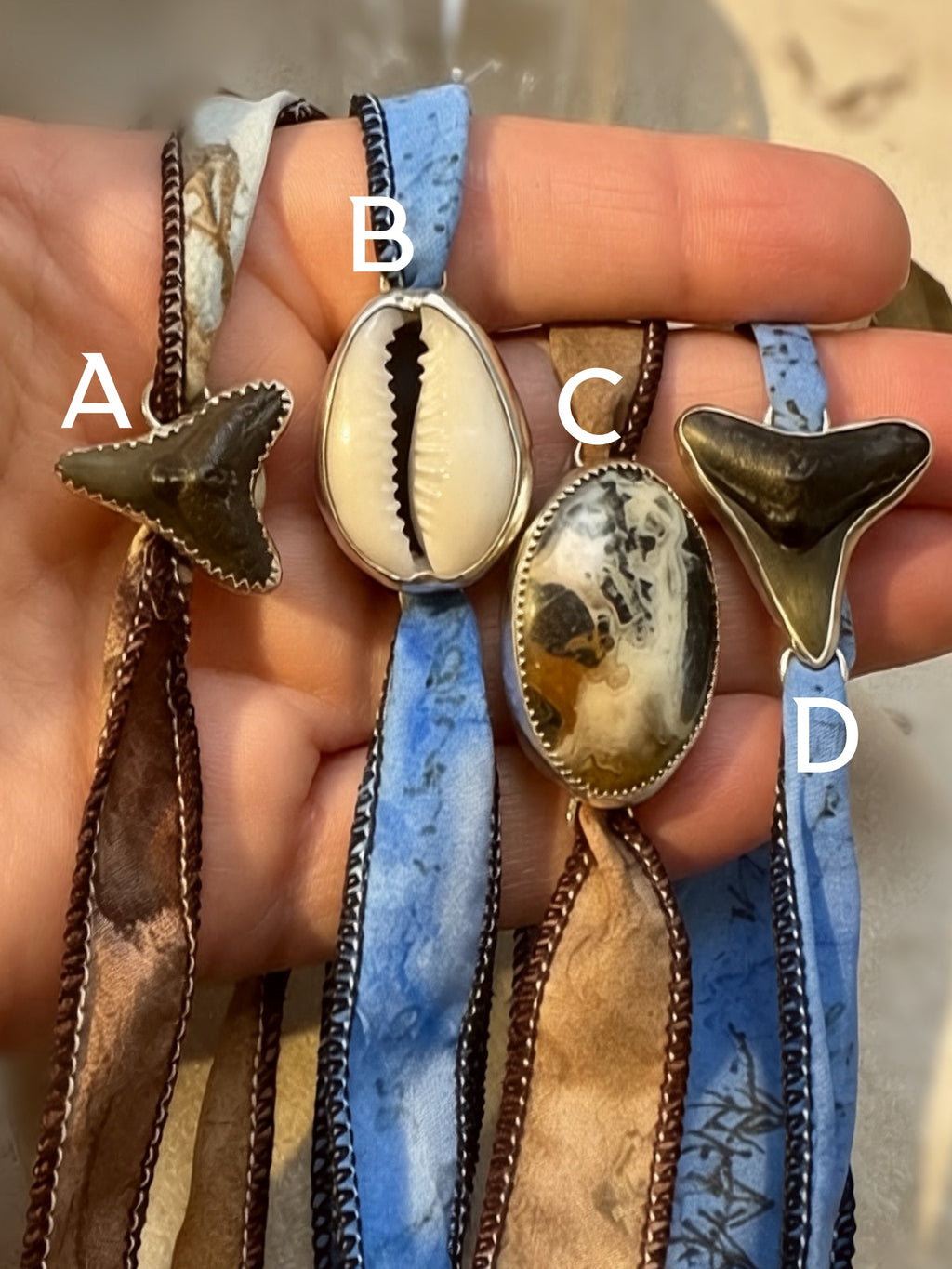 Handmade silk wrap bracelets with fossil shark tooth, cowrie shell, and crazy lace agate set in fine and sterling silver.