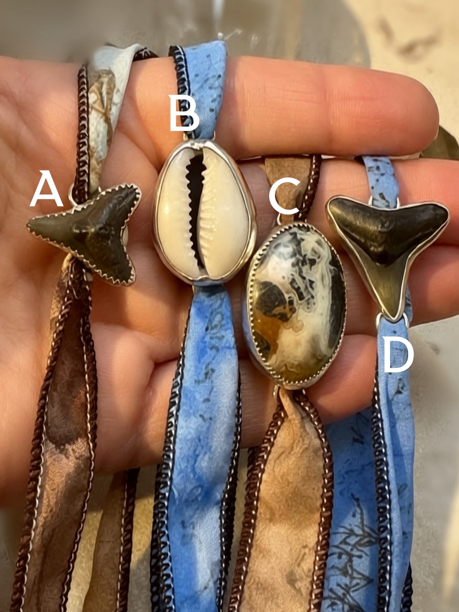 Handmade silk wrap bracelets with fossil shark tooth, cowrie shell, and crazy lace agate set in fine and sterling silver.