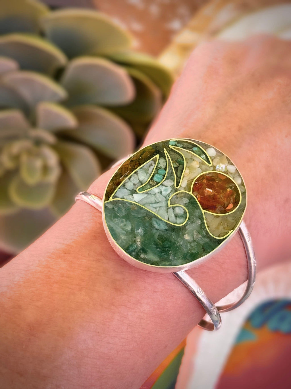 Close-up of crushed stone mosaic inlay work showing aquamarine, fire opal, tiger's eye, turquoise, yellow opal and larimar framed by fine silver