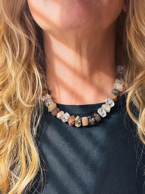Threaded Light rutilated quartz statement necklace worn at the collarbone, showing varied translucent faceted stones and graphite silk knots.